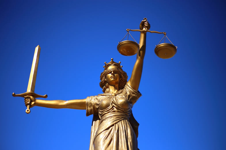 Image symbolisant la justice sous la forme d'une déesse aux yeux bandés tenant la balance | Justbob